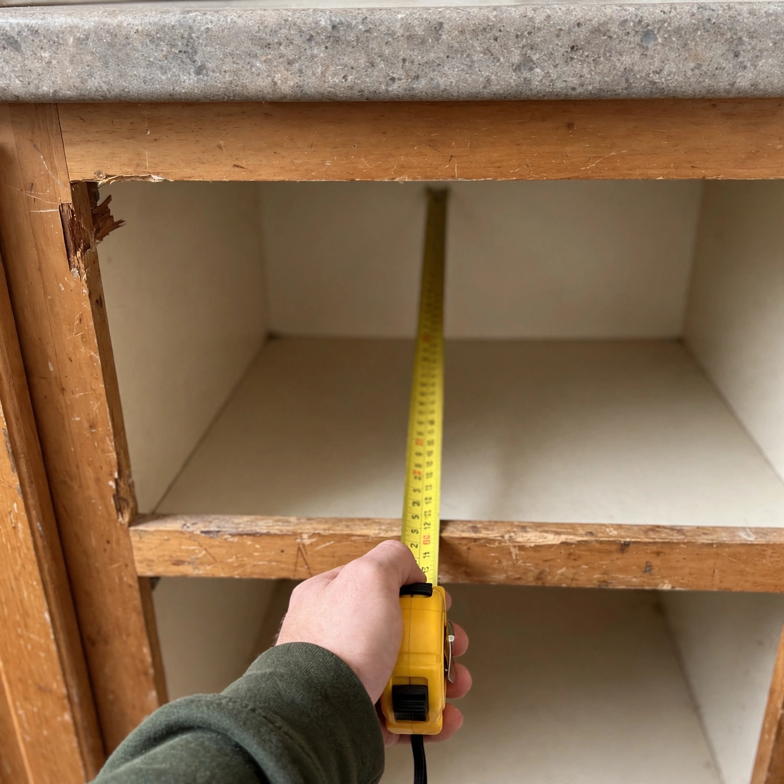 Kitchen counter with a tape measure showing cabinet depth
