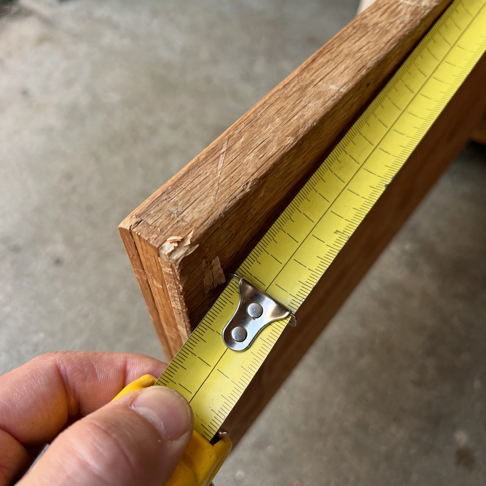 Close-up of a dresser corner showing a small chip and wood grain near the pickup spot.
