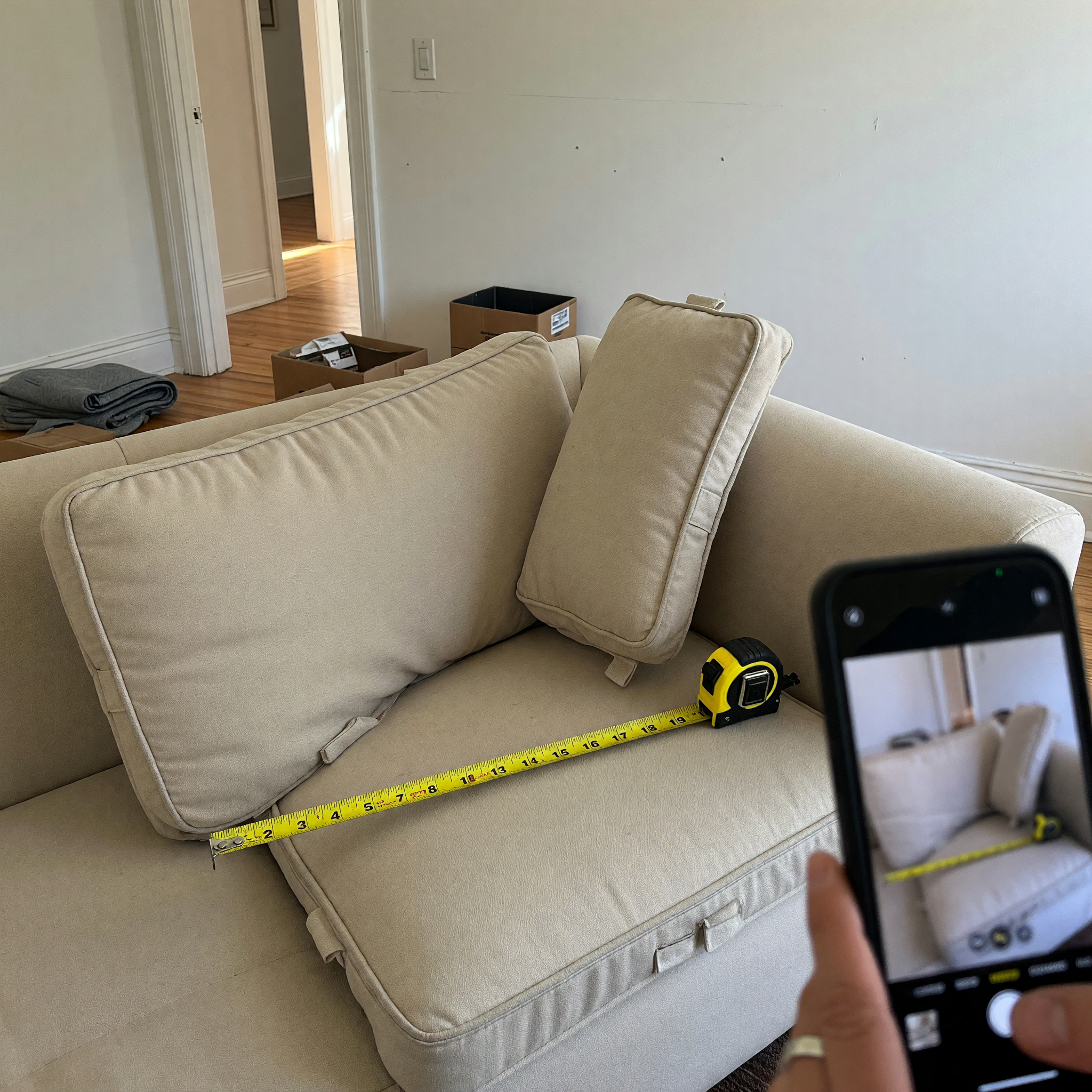 Tape measure on a clean sofa being photographed for a free furniture pickup listing