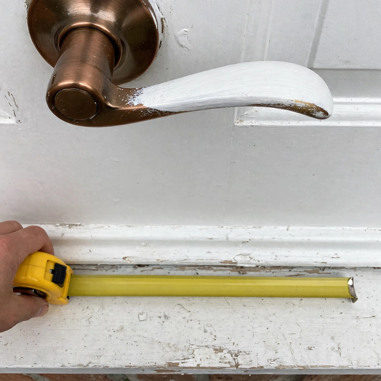 Close-up of a freshly painted front door handle and threshold detail