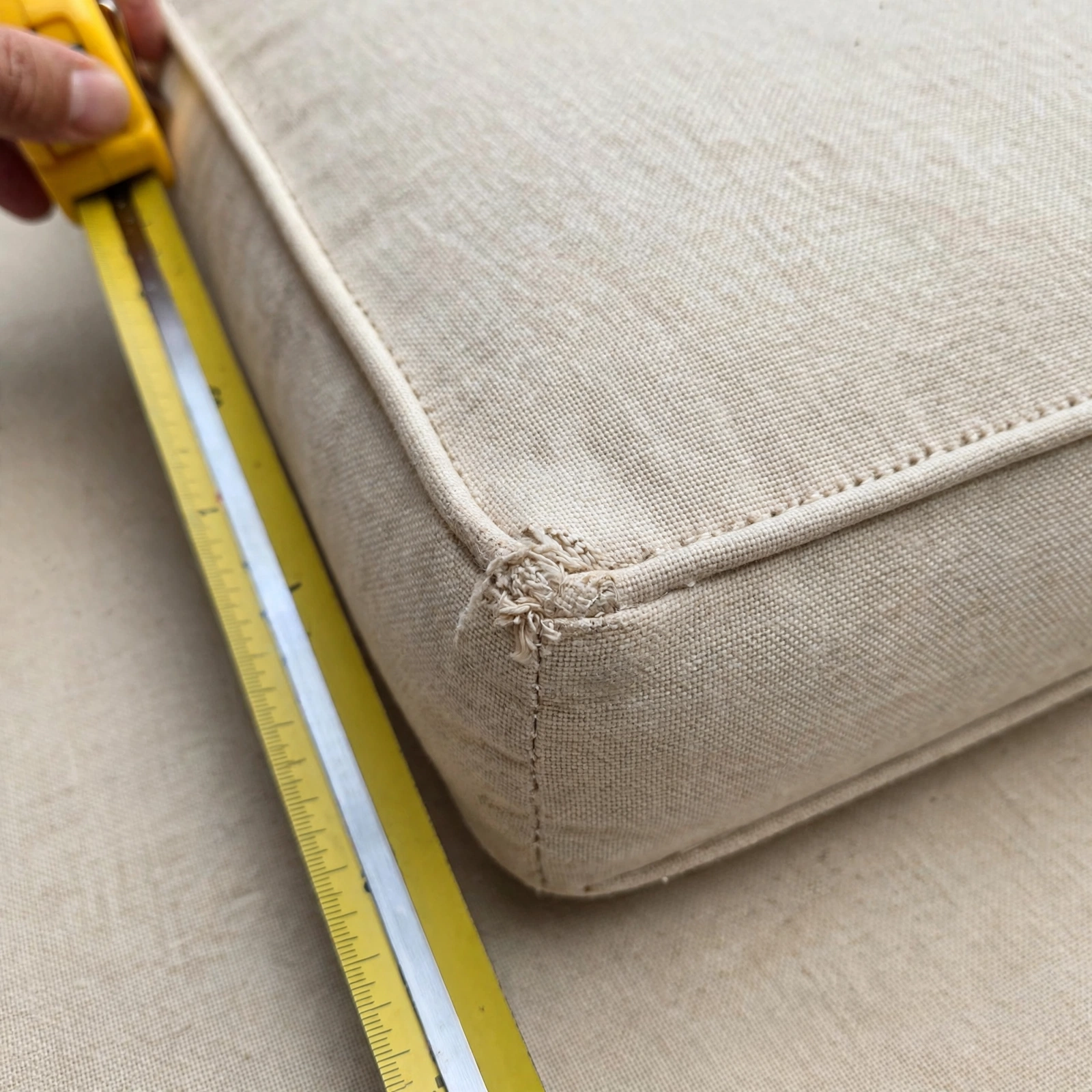 A close-up of one cushion corner showing a small wear mark and stitching detail